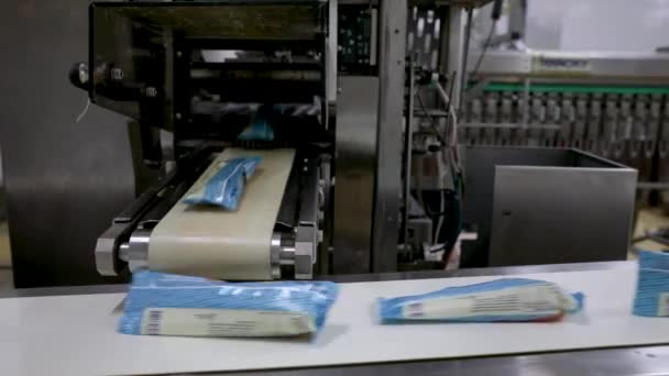 食品産業と技術について プラスチックパッケージでアイスクリームポップスを包む商業包装機のクローズアップビュー — ストック動画