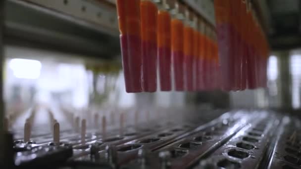 食品産業について 食品加工と製造における技術とオートメーション 商業的なイチゴとオレンジ風味のポップスデビューマシンをクローズアップ — ストック動画