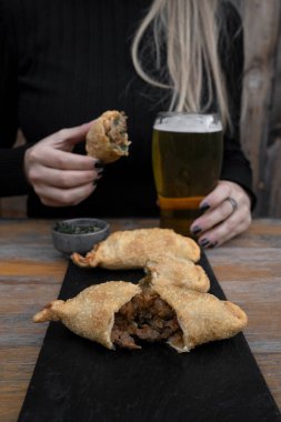 Restoranda börek yiyorum. Kafkasyalı bir kadının geleneksel chimichurri soslu kızarmış et böreği yerken yakın plan görüntüsü..