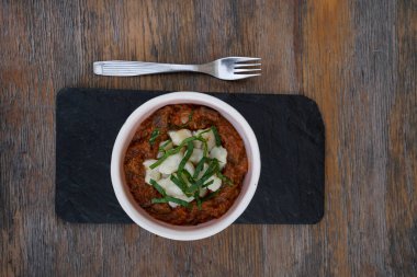 Geleneksel Macar yemeğinin en iyi manzarası, dana eti ve gnocchi ile gulaş güveci, restoranın ahşap masasında siyah bir tabakta..