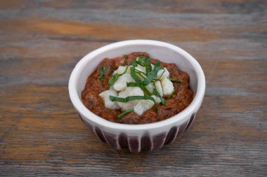 Geleneksel Macar yemeği, gulaş yahnisi, dana eti ve gnocchi, restoranın ahşap masasında..