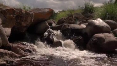 Akıntılar. Kayalık tepenin üzerinden akan nehrin görüntüsü.
