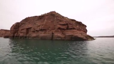 Turizm. Pov. Gölde gezinen geminin görüntüsü. Turuncu kaya oluşumları El Choco, Patagonya Arjantin 'de devler olarak adlandırılır..