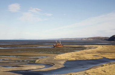 Doğa dokuları. Körfez, okyanus, sahil, sahil ve terk edilmiş eski gemi enkazı kıyıda karaya oturmuş..