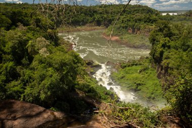 Tropikal yağmur ormanlarındaki şelaleler. Nehre akan akıntılar yeşil ormanı ve tepeleri aşıyor..