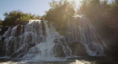 Unique view of the Mocona falls from the boat. The beautiful waterfalls, rocky cliffs, falling white water and river flowing across the jungle in Misiones, Argentina. clipart