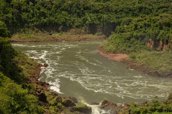 stock image Small boat sailing along the Iguazu river in the jungle. The rapids and lush vegetation in Iguazu national park in Misiones, Argentina.