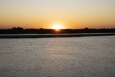 Gün batımında nehrin manzarası. Güneş ufukta saklanıyor. 