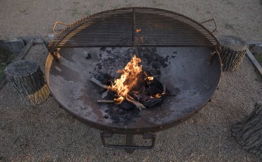 Dışarıda yemek pişirmek. Barbekü. Bahçedeki geleneksel paslı ızgarada yanan kömür ve odun manzarası.. 
