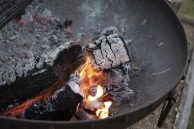 Açık hava yemekleri için ateş yakıyorum. Yanan odun ve kömür