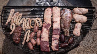 Cooking outdoors. Roasting meat in the metal grill.  clipart