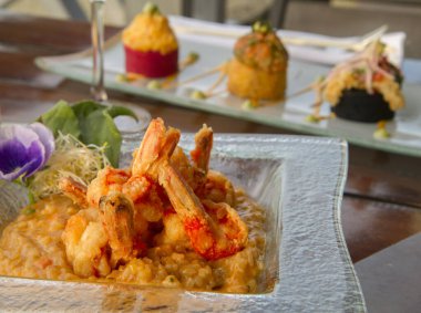 Gurme deniz ürünleri. Zarif bir restoran ve yemek sunumu. Akdeniz pilavı üzerine kızarmış karides.. 