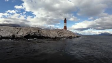 Arjantin 'in Tierra del Fuego adasındaki kayalık bir adada bulunan Les Eclaireurs anıtının görüntüsü. Feribot ve karabatak kuşlarının görkemli bir gökyüzünün altında yuvalandığı yer.