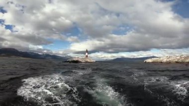 Beagle Kanalı 'nda okyanusa yelken açmak kayalık adadan uzakta Les Eclaireurs deniz fenerinin bulunduğu yerde bulutlarla kaplı güzel bir gökyüzünün altında duruyor.