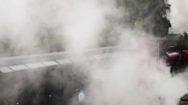 Dünyanın öbür ucundaki tren. Tierra del Fuego Ulusal Parkı 'ndaki istasyondan çıkan kırmızı buharlı lokomotifin görüntüsü. Lokomotiften güzel beyaz bir duman çıkıyor.. 