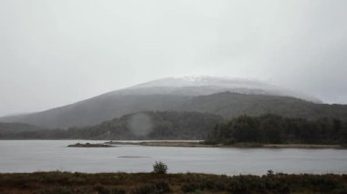 Tierra del Fuego Ulusal Parkı 'nda yağmur yağıyor. Yağmurlu bir sabahta göl, orman ve dağların manzarası
