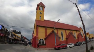 Tierra del Fuego, Arjantin 04,25,2025: Patagonya 'da şehir hayatı. Ushuaia şehrindeki eski bir şapelin manzarası. Yürüyen insanlar ve cadde boyunca giden arabalar.