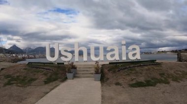 Ushuaia işaretinin panorama manzarası. And Dağları, liman ve Beagle Kanalı okyanusu arka planda.
