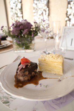 Sosyal bir etkinlikte gurme gastronomisi. Yakından bakınca soslu ızgara fileto ve galada beyaz bir tabakta patates mili feuille.