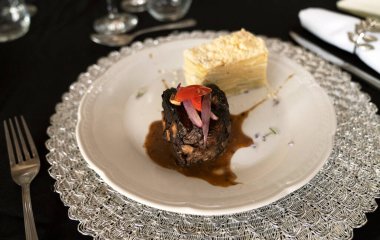 Sosyal bir etkinlikte gurme gastronomisi. Yakından bakınca soslu ızgara fileto ve galada beyaz bir tabakta patates mili feuille.