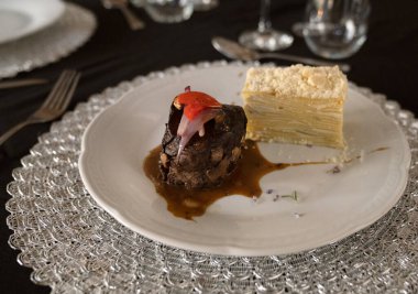 Sosyal bir etkinlikte gurme gastronomisi. Yakından bakınca soslu ızgara fileto ve galada beyaz bir tabakta patates mili feuille.