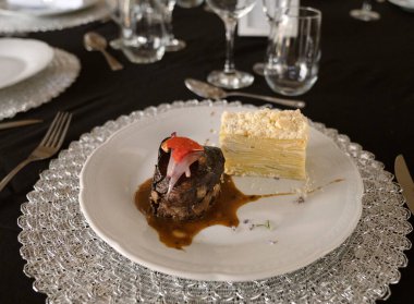 Sosyal bir etkinlikte gurme gastronomisi. Yakından bakınca soslu ızgara fileto ve galada beyaz bir tabakta patates mili feuille.