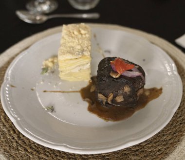 Sosyal bir etkinlikte gurme gastronomisi. Yakından bakınca soslu ızgara fileto ve galada beyaz bir tabakta patates mili feuille.