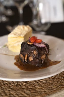 Sosyal bir etkinlikte gurme gastronomisi. Yakından bakınca soslu ızgara fileto ve galada beyaz bir tabakta patates mili feuille.