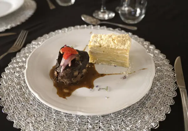 Sosyal bir etkinlikte gurme gastronomisi. Yakından bakınca soslu ızgara fileto ve galada beyaz bir tabakta patates mili feuille.