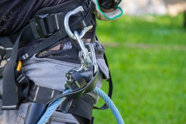 Karabinalar, halatlar ve kemerden oluşan bir budama makinesi için güvenlik ekipmanı. Tehlikeli iş..