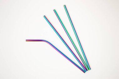 Beyaz arka planda izole edilmiş renkli yeniden kullanılabilir metal pipetler. Sıfır plastik kavram.