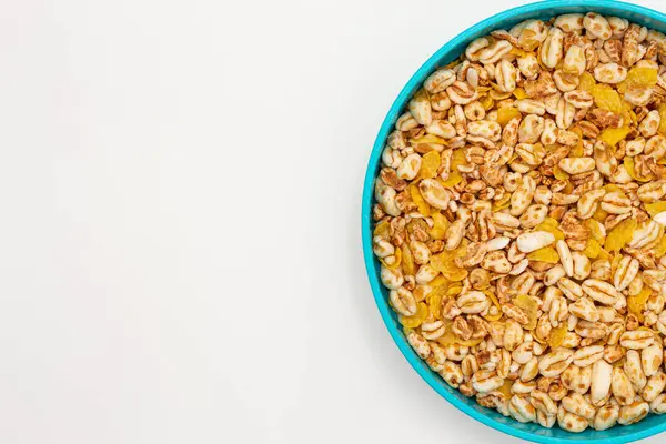 Puffed wheat and unsweetened corn in a bowl. Example of a healthy vegan breakfast. Top image with white background and copy space.
