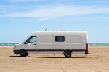 İspanya, Ebro Delta 'da deniz kenarında park edilmiş eski beyaz bir karavan. Göçebe ve özgür yaşam.