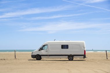 İspanya, Ebro Delta 'da deniz kenarında park edilmiş eski beyaz bir karavan. Göçebe ve özgür yaşam.