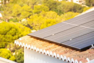 Güneş paneli bir villanın çatısına monte edildi ve güneş onun üzerinde parladı..