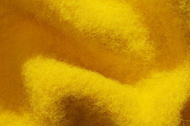 Katlanmış sarı pamuk kumaş dokusu. Makrofotoğrafçılık.