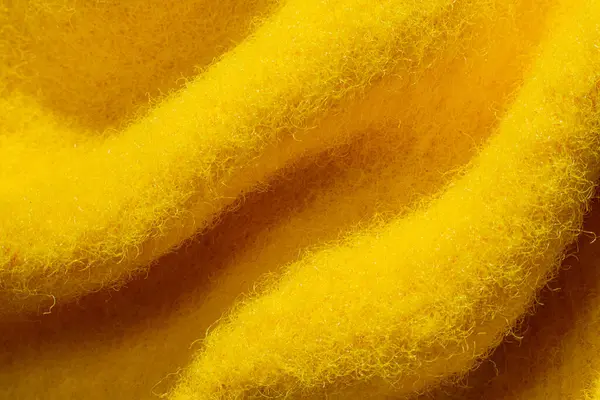 Kırışıklıkları olan sarı pamuk kumaş dokusu. Makro resim.