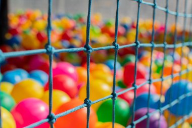 Bir oyun parkında birçok renkten plastik toplar yığını.