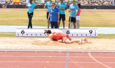 Atletizm sporcuları sahada koşuyor.