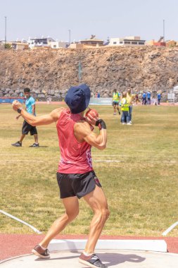 Kırmızı toplu mavi üniformalı bir adam.