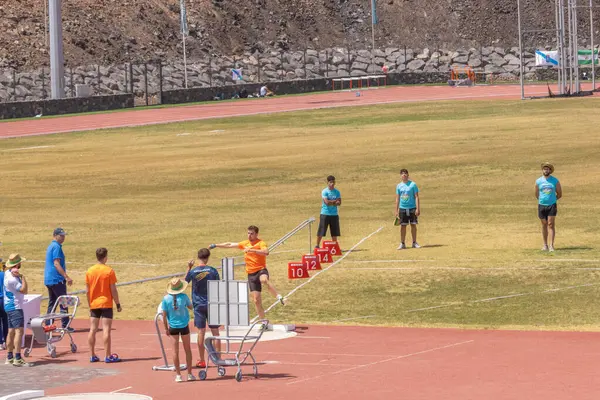 Gençler stadyumdaki pistte koşuyor.