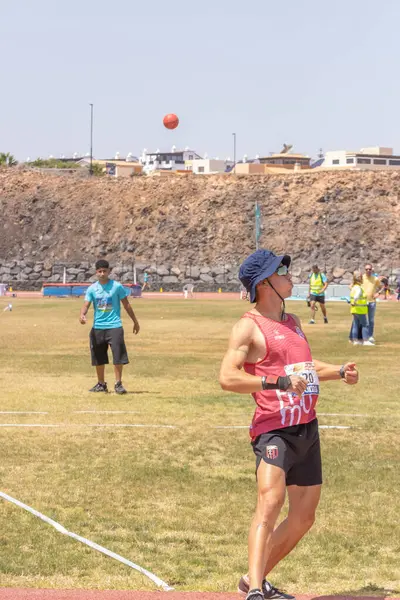 Sahilde elinde top olan bir kadın.