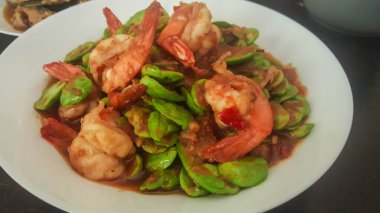 Kokulu fasulyeli kızarmış karides ya da karides ezmesi Güney Tayland usulü yiyecek.