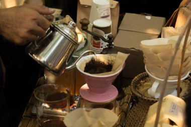 Elden damlayan kahve, barista filtreli kahve zeminine su döker..