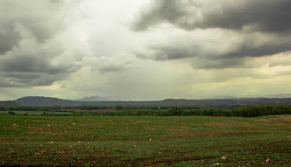 Landscape of rain and clouds over country field