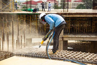 Yapı inşaatında kumdan çeliğe çalışan bir adam. 