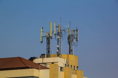 Cep telefonu telekomünikasyon antenler ve açık mavi gökyüzü karşı binasında Tekrarlayıcı