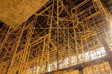 İnşaat iskelesi. İnşaat alanında iskeleyle kaplı bir bina.