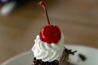 Yakın plan çikolatalı pasta ve kirazlı ahşap arka plan