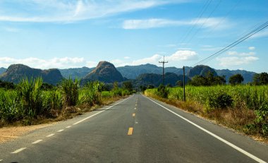asfalt otoyol ve mavi gökyüzünün altındaki tepeler